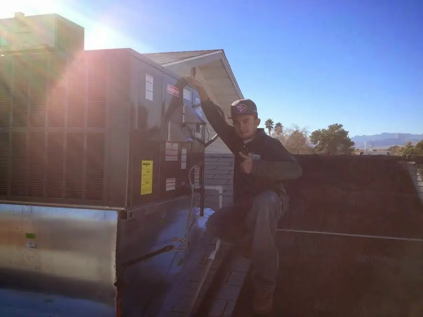 HVAC technician performing AC Tune-Up on a rooftop unit in Rosemont